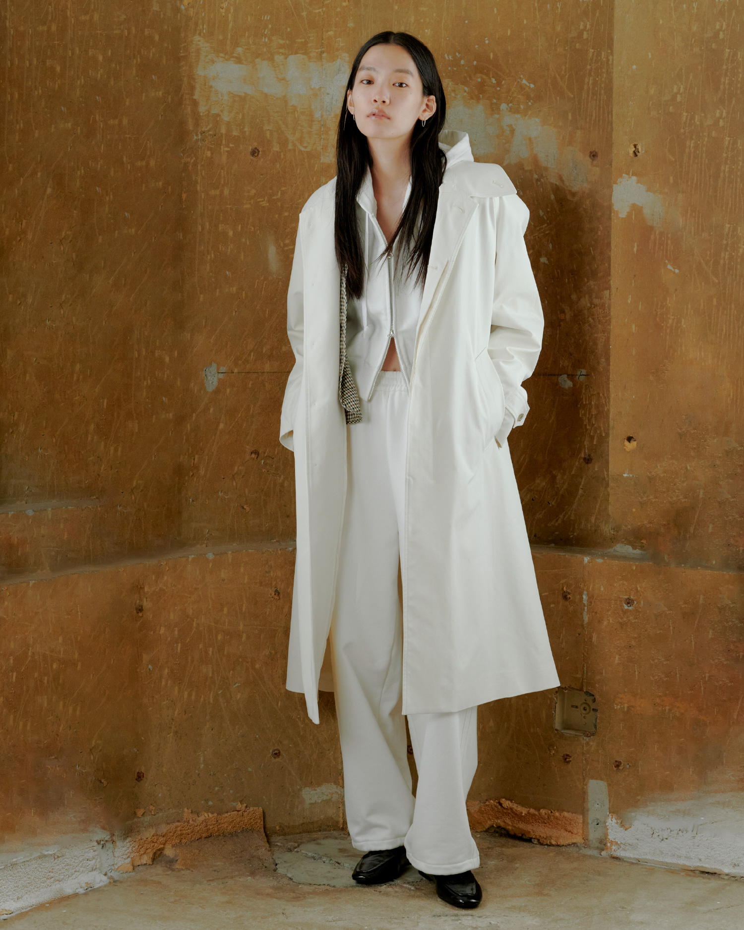 フードマフラー付きスプリングコート&スウェット短丈ジップトップス&サイドラインスウェットパンツを着用した女性