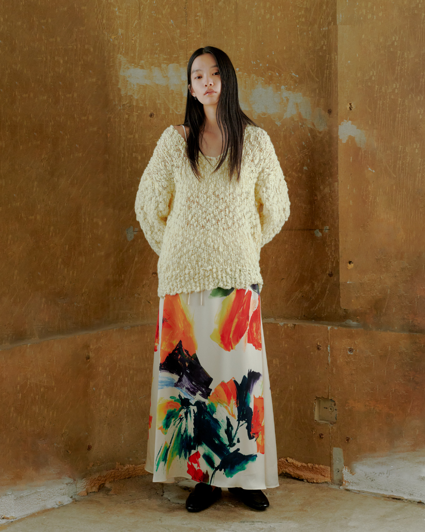 オーバーサイズVネックチャンキーニット&ベルテッドナロースカートを着用した女性